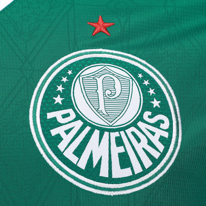 Detalhe do escudo bordado da Camisa Palmeiras Home 25/26, destacando a tradição do Maior Campeão do Brasil.